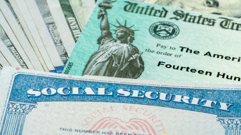 A stack of social security card, checks, and cash