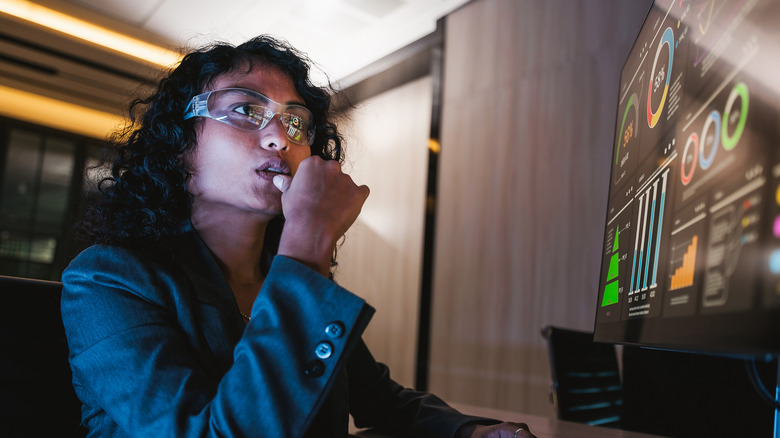 A young woman analyzing charts and considering investment opportunities