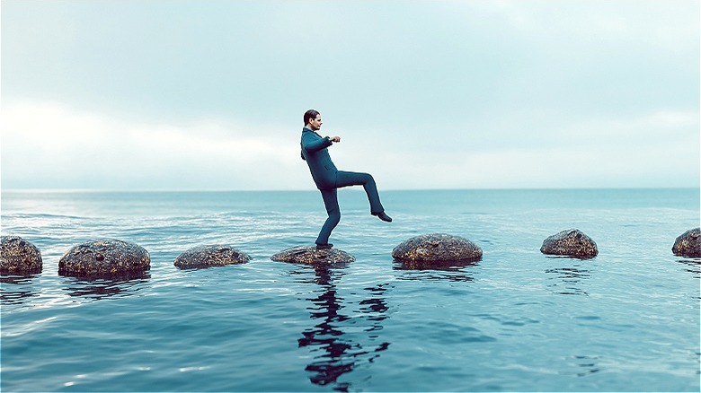 Person crossing water on stones