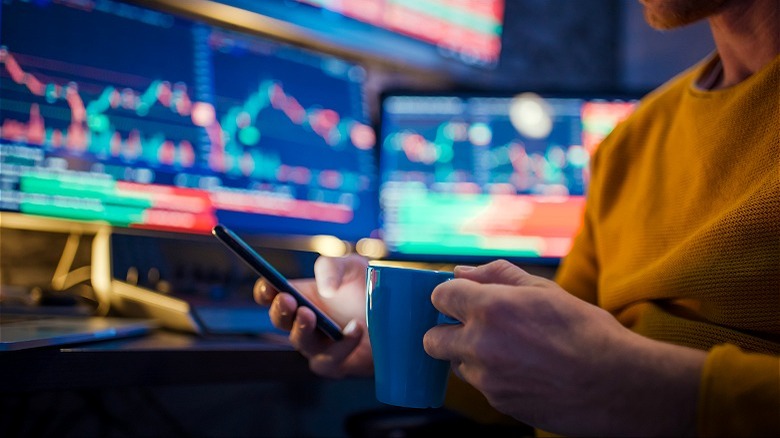 Trader drinking coffee, reading data