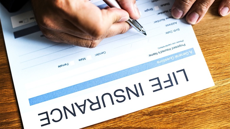 Person filling life insurance paperwork