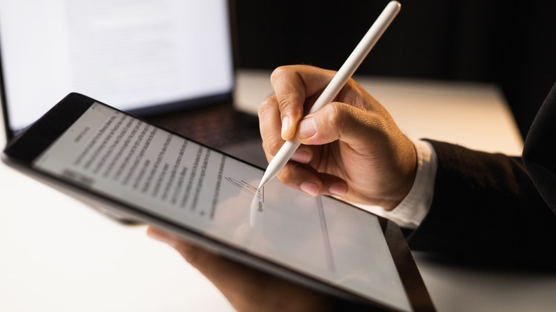 A man signing a tablet