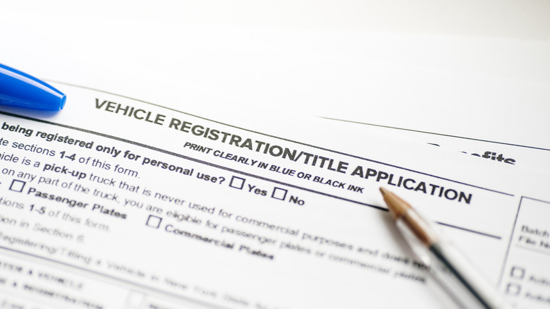 Vehicle registration paperwork with a pen