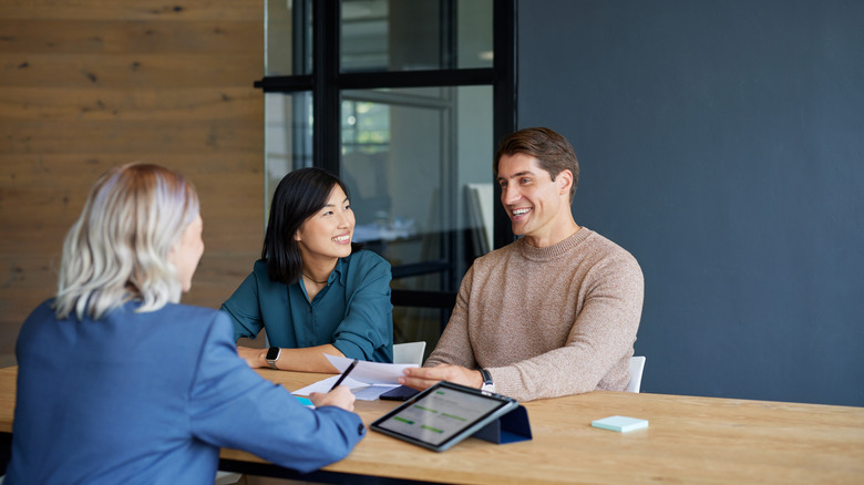 Couple sitting in a bank talking to a customer service representative