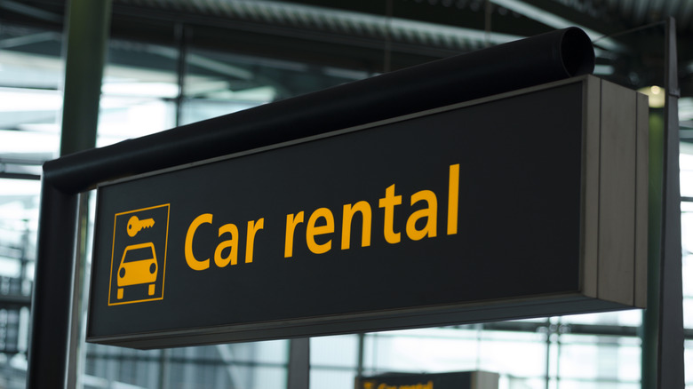 Sign with direction to car rental.