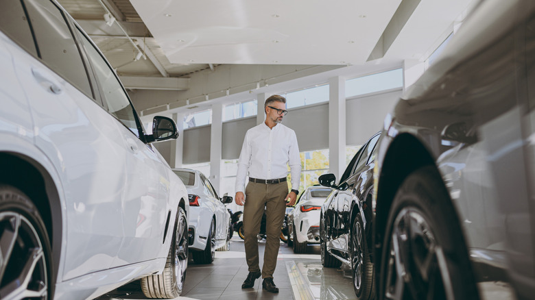 A man looking at cars in a dealership